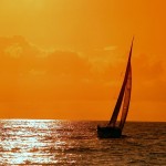 orange sunset over the sea with sail boat