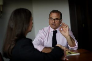 Steve Giglio at a table conducting sales training with a corporate executive woman