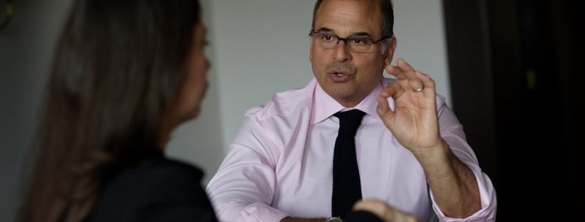 Steve Giglio at a table conducting sales training with a corporate executive woman