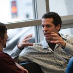 two business men sitting and talking