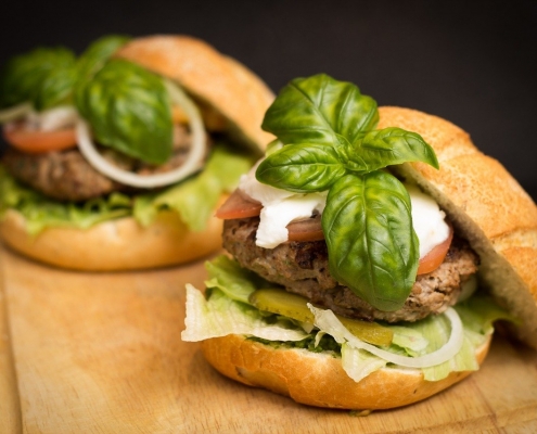 two gourmet hamburgers with basil