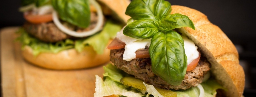 two gourmet hamburgers with basil